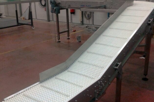 Convoyeur incliné à bande modulaire conçu pour optimiser l'accumulation et le transport de produits, comme des cartons et des bacs, tout en s’adaptant aux contraintes spécifiques des environnements industriels.