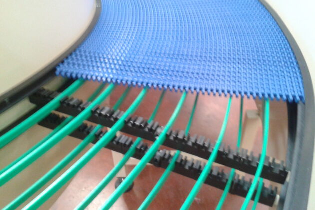 Cette image montre un convoyeur à bande modulaire conçu pour optimiser l'accumulation et le transport de produits, comme des cartons et des bacs, tout en s’adaptant aux contraintes spécifiques des environnements industriels. Sa structure modulaire permet de configurer facilement des courbes et des changements de niveaux pour répondre aux besoins particuliers de chaque installation. Résistant aux lavages à grandes eaux et à l’utilisation de produits désinfectants, ce convoyeur garantit des conditions de propreté et d’hygiène optimales, idéales pour les secteurs nécessitant des normes sanitaires rigoureuses. Polyvalent et durable, il permet aux entreprises d'améliorer la gestion des flux de production, en alliant efficacité et hygiène