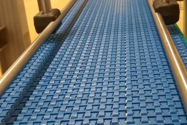 Cette image présente un convoyeur à bande modulaire, conçu pour répondre aux besoins de gestion de l'accumulation de produits tels que des cartons et des bacs, tout en s’adaptant aux spécificités de l’environnement industriel du client. Grâce à sa conception modulaire, ce convoyeur peut gérer des changements de direction (courbes) et de niveau (élévations), assurant une intégration optimale dans divers agencements industriels. En plus de sa flexibilité, ce convoyeur est fabriqué pour résister aux nettoyages fréquents à grandes eaux et aux produits désinfectants, garantissant une hygiène maximale pour des secteurs tels que l'agroalimentaire et le pharmaceutique. Ce convoyeur représente une solution idéale pour optimiser les processus de production tout en maintenant des standards élevés de propreté et de durabilité.