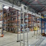 Structure aérienne porteuse supportant une ligne de convoyage dans un environnement agroalimentaire, optimisant le transport des produits.