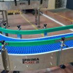 Convoyeur à bande modulaire courbe, conçu pour répondre aux besoins de gestion de l'accumulation de produits tels que des cartons et des bacs, tout en s’adaptant aux spécificités de l’environnement industriel du client.