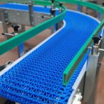 Convoyeur courbe à bande modulaire, conçu pour répondre aux besoins de gestion de l'accumulation de produits tels que des cartons et des bacs, tout en s’adaptant aux spécificités de l’environnement industriel du client.