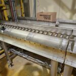 Ensemble robotisé associé à un convoyeur, conçu pour automatiser les tâches de dépalettisation et de décartonnage dans un environnement industriel.