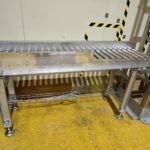 Convoyeur industriel à rouleaux spécialement conçu pour fonctionner dans un environnement soumis à des lavages à grandes eaux et à l'utilisation de produits désinfectants.