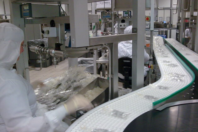 Convoyeur courbe à bande modulaire, conçu pour répondre aux besoins de gestion de l'accumulation de produits tels que des cartons et des bacs, tout en s’adaptant aux spécificités de l’environnement industriel du client.