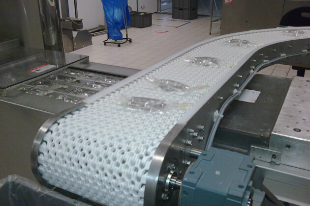 Convoyeur courbe à bande modulaire, conçu pour répondre aux besoins de gestion de l'accumulation de produits tels que des cartons et des bacs, tout en s’adaptant aux spécificités de l’environnement industriel du client.